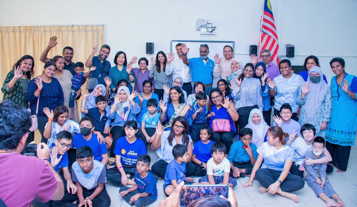 A group of adults and children pose for photos to celebrate Autism Awareness Month at Taarana School.