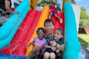 Sensory day. F A man with two kids sliding down the slide for sensory day