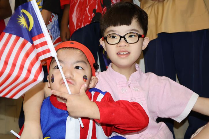 2 boys posing with malaysia flag