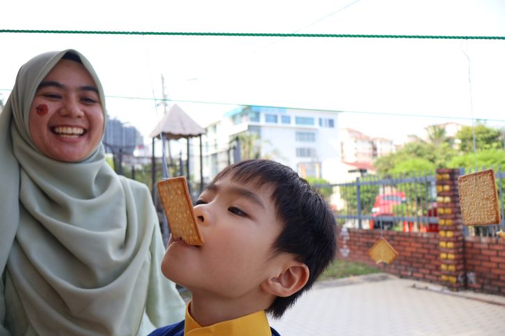 A boy bites a biscuit